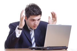Man getting visibily frustrated with a laptop